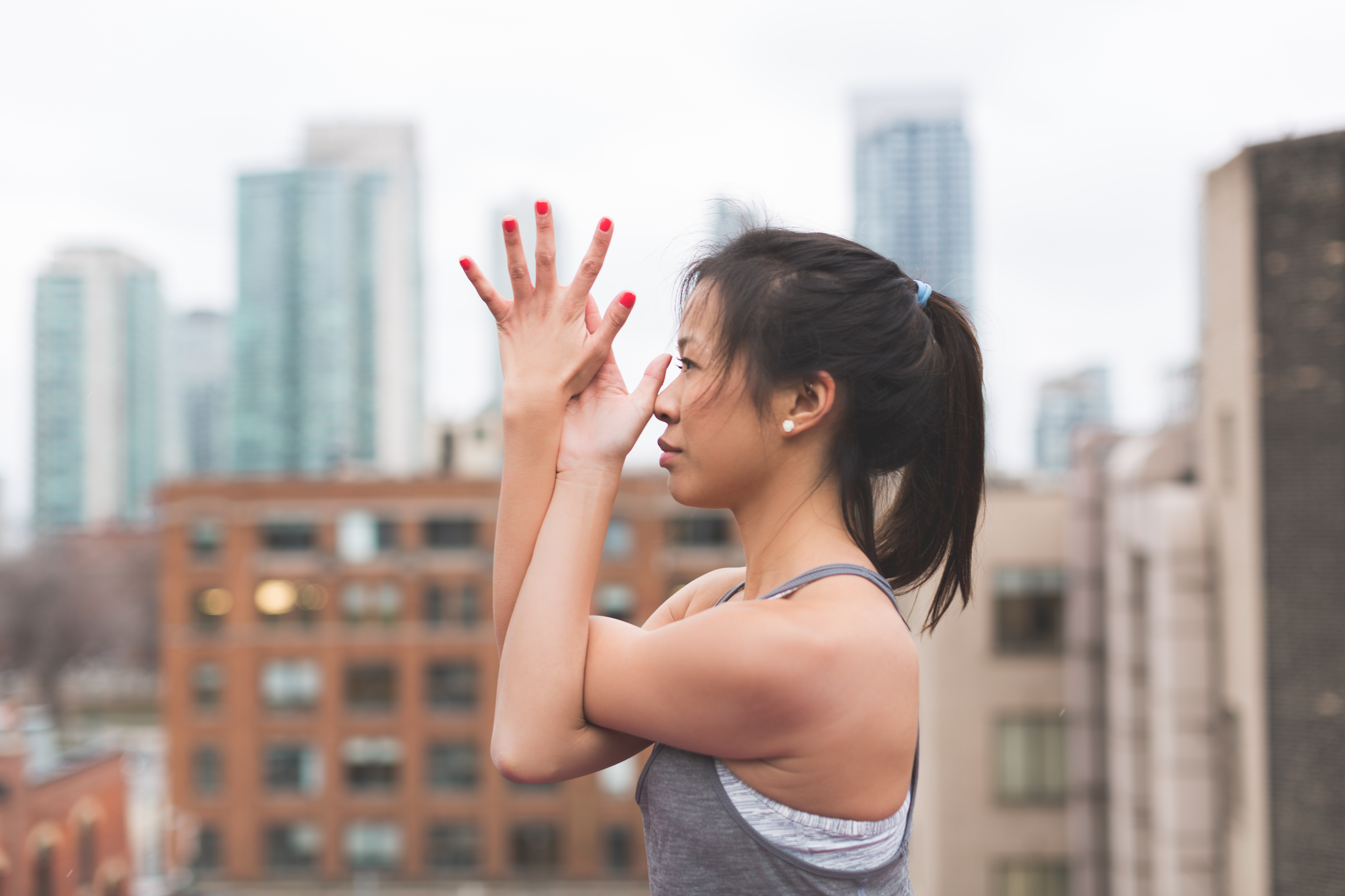 A woman doing yoga on a city rooftop