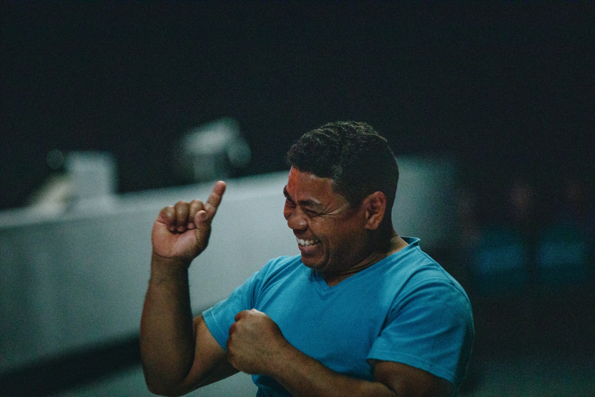 A Deaf man signs while smiling widely