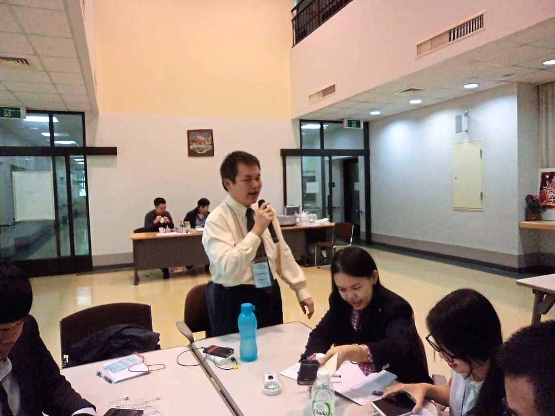 A man speaking into a microphone in front of a table