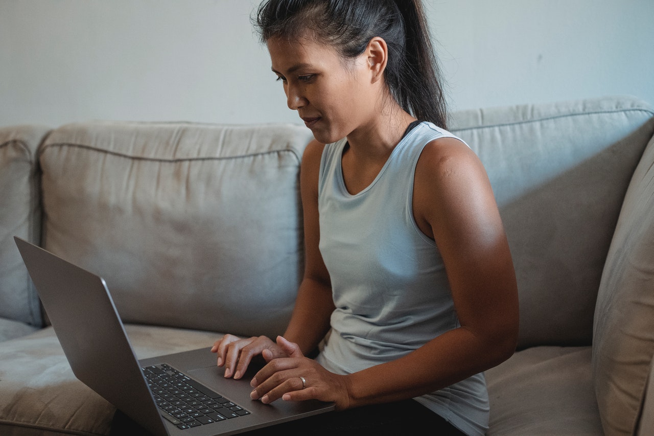 A woman sitting on a couch with a laptop